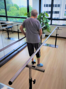 Gait training with parallel bar to help stroke patient improve in balance and walking ability.